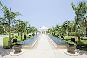 Gartenweg zum Gebäude des Swahili Beach Resorts mit Wasserläufen und Palmen
