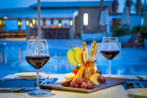 Adams Beach Hotel: Obstplatte mit Wein auf dem Tisch am Pool.