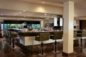 Barlounge im Adams Beach Hotel mit Barhockern und vielen Getränken.