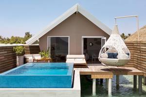 Außenbereich des LUX South Ari Atoll Wasserbungalows mit Swimmingpool und Hängesessel