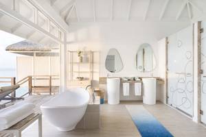 Ein Badezimmer im LUX South Ari Atoll Hotel mit großer Badewanne und zwei Waschbecken.