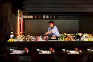 Sushi-Buffet im LUX South Ari Atoll Hotel mit verschiedenen Gerichten und einem Koch.