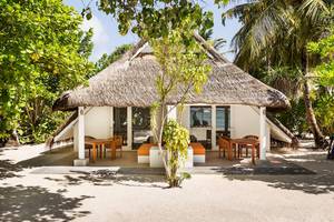 Strandhütte im LUX South Ari Atoll Hotel mit Meerblick und Möbeln auf der Veranda.