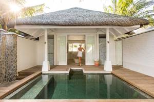 LUX South Ari Atoll Wasservilla mit Pool, Frau in weiss steht vor Eingang