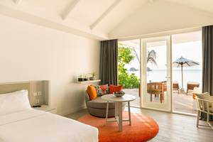 Luxuriöses Zimmer im LUX South Ari Atoll Hotel mit Meerblick, offener Terrasse und modernen Möbeln.