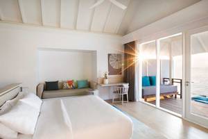 Luxuriöses Zimmer im LUX South Ari Atoll Hotel mit Blick auf das Meer und Sonnenlicht.