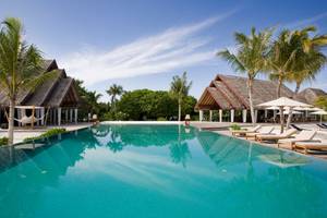 Außenpool mit Sonnenliegen und Sonnenschirmen im LUX South Ari Atoll