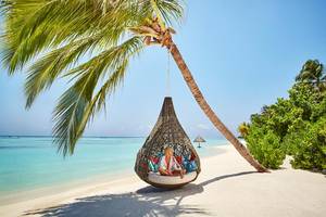 Frau in einer Wiege am Strand des LUX South Ari Atoll