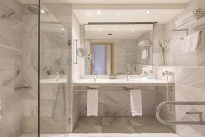 Badezimmer im Hipotels Said mit Marmorboden, großer Dusche und Doppelwaschbecken.