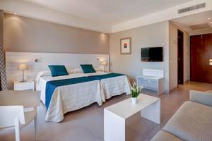Schlafzimmer im Hipotels Said Hotel mit zwei Betten, Fernseher und Wohnzimmerecke.