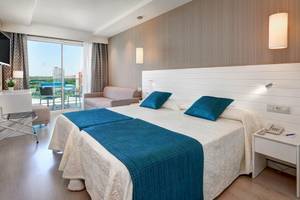 Doppelzimmer im Hipotels Said mit zwei Betten, blauen Kissen und Blick auf die Terrasse.