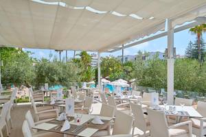 Restaurantterrasse des Hipotels Said mit Tischen, Stühlen und einem Blick auf den Pool.