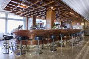 Rezeption des Hipotels Said Hotels mit Bar, Stühlen und Blumenarrangement.