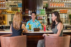 Besuch im Barbereich des Fujairah Rotana Resort & Spa mit zwei Frauen und einem Barkeeper