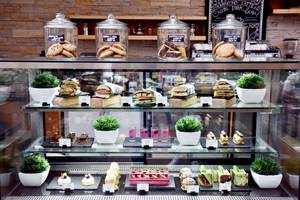 Kuchenbuffet im Fujairah Rotana Resort & Spa mit verschiedenen Kuchen, Keksen und Sandwiches.