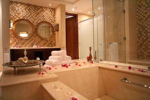 Badezimmer im Pickalbatros The Palace Port Ghalib Hotel mit Jacuzzi, Rosenblättern und Marmorfliesen.