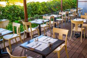 Terrasse des Hersonissos Palace Hotels mit gedeckten Tischen und Stühle an einem sonnigen Tag.