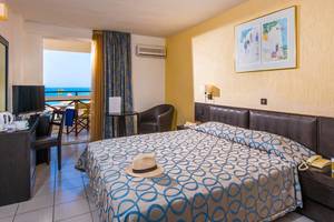 Ein Hotelzimmer im Hersonissos Palace mit Blick auf das Meer und moderne Einrichtung.