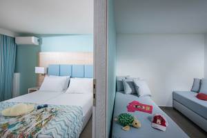Doppelzimmer-Innenansicht im Odyssia Beach Hotel mit zwei Betten, blauen Wänden und hellem Dekor.