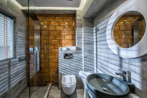 Badezimmer im Odyssia Beach Hotel mit Dusche, Toilette und Waschbecken.