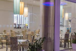 Innenansicht des Stamatia Hotel Restaurants mit runden Tischdecken und hängenden Lampen.