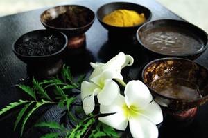 Spa-Produkte auf dem Biyadhoo Island Resort, darunter Blumen und verschiedene Paste.