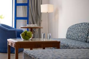 Hotelzimmer des Mitsis Norida Beach mit Couch, Tisch, Lamp und Obstschale