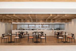 Innenansicht des Restaurants im Mitsis Norida Beach Hotel mit Holzboden und modernen Möbeln.