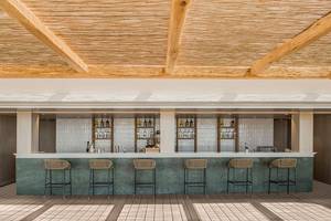 Bar-Terrasse im Mitsis Norida Beach Hotel mit Holzsäulen und Weinfässern.