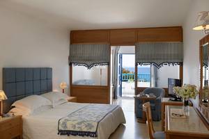 Schlafzimmer im Mitsis Norida Beach Hotel mit Blick auf das Meer und Balkon.