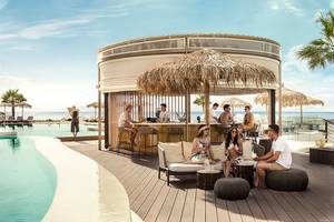 Gäste entspannen an der Terrasse des Mitsis Norida Beach Hotels mit Blick auf das Meer.
