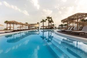Außenpoolbereich des Mitsis Norida Beach Hotels mit Loungeliegen und Palmen