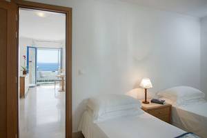 Zimmer im Mitsis Norida Beach Hotel mit Blick auf das Meer von einer Terrasse.