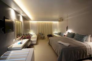 Das Schlafzimmer im MykonosView Hotel mit einem großen Bett, Dekor und Möbeln.