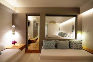 Schlafzimmer des MykonosView Hotels mit Bett, Spiegel und Dekor.