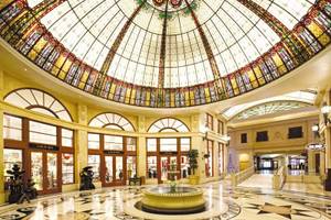 Innenhof des Paris Las Vegas Hotels mit buntem Glasdach, Brunnen und Geschäften.