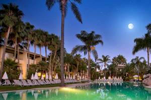 Der Pool des Bluebay Banus Hotels bei Nacht mit Vollmond und Palmen