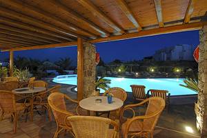 Außenterrasse des Kamari Hotels bei Nacht mit Blick auf den Pool und beleuchteten Gebäuden.