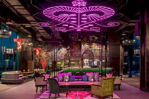 Loungebereich des W Dubai - The Palm Hotels mit lila Beleuchtung und modernen Möbeln.