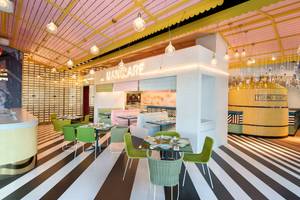 Innenansicht des Restaurants im W Dubai - The Palm mit bunten Stühlen und Tischen.