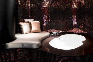 Badezimmer im W Dubai - The Palm mit geschwungener Bank, Kissen und Badewanne.