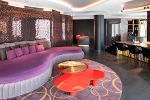 Lobby-Lounge-Bereich des W Dubai - The Palm Hotels mit einer violetten Couch und einem roten Tisch.