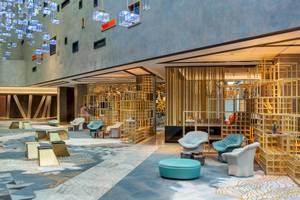 Lobby des W Dubai - The Palm Hotels mit goldenen Strukturen und modernen Möbeln.