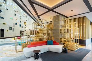 Lobby des W Dubai - The Palm Hotels mit modernen Möbeln und goldenen Strukturen.