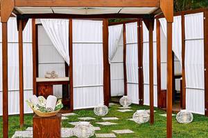 Spa-Bereich im Atlantica Akti Zeus Hotel mit Holzpavillon und weißen Vorhängen.