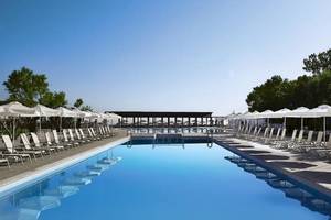 Außenpool des Atlantica Akti Zeus Hotels mit weißen Sonnenliegen und Schirmen