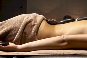 Eine Person im Lagomandra Beach Hotel genießt eine Massage mit heißen Steinen.