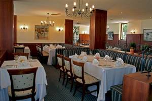 Speisesaal im Riviera Beach Hotel mit gedeckten Tischen und Stühlen.