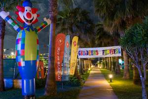 Eingang zum Kinderfestival mit einer großen Clown-Aufblasfigur und bunten Bannern.