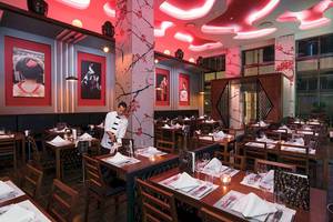 Innenansicht des Restaurants im Riu Palace Las Americas mit rotem Thema und japanischen Gemälden an den Wänden.